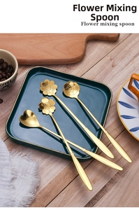 Detail shot of four golden stainless steel flower-shaped spoons on a ceramic tray
