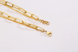 Detail of gold double-layer necklace featuring fine chain and rectangular link chain
