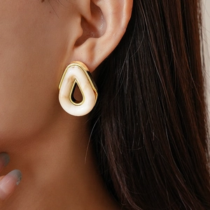 Vintage teardrop resin earrings with gold metal frame worn by a model in a close-up view