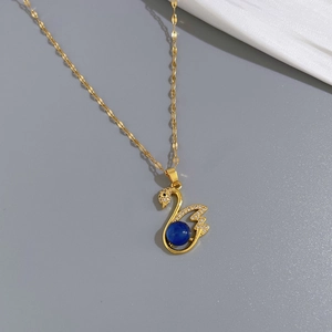 Detailed close-up of golden swan pendant with micro-set zircons and a deep blue gemstone