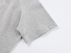 Close-up of shoulder stitching and grey knit fabric texture on a loose off-shoulder T-shirt