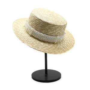Détail du ruban de perles blanches sur un chapeau de paille canotier élégant