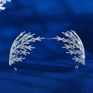 Gros plan du serre-tête de mariée argenté avec feuilles en strass sur velours bleu