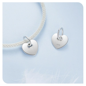 Macro detail of S925 sterling silver heart charm with certification hallmark on a bracelet