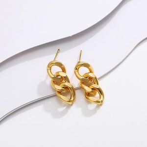 Dettaglio di orecchini pendenti a catena cubana lunga placcati in oro 18K su sfondo bianco