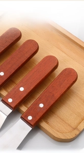 Close-up of ergonomic redwood handle with rivets on stainless steel offset spatula