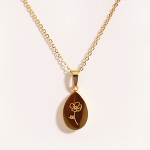 Collier élégant en acier inoxydable doré avec pendentif goutte ambre et motif fleur