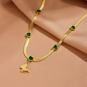 Collier papillon doré avec pierres de cœur vertes sur fond de soie élégant et chic