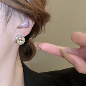 Elegante champagner goldene Spiral-Ohrringe mit Perlen und Kristallen am Ohr