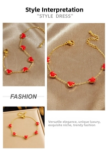 Detail of a gold-plated stainless steel bracelet with red enamel heart charms on silk