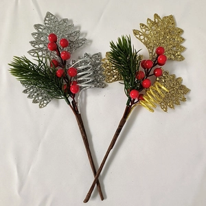 Detail of glittered leaves and red berries on festive Christmas branches for tree decoration