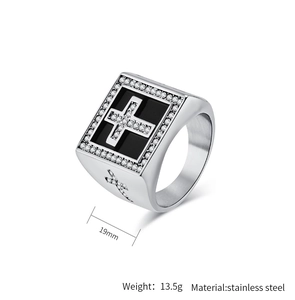 Macro detail of men's silver and black stainless steel signet ring with side cross design