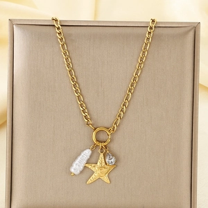 Détail du collier doré avec pendentif étoile de mer, perle baroque et zircon goutte