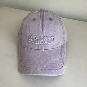 Detail of vintage washed purple cotton baseball cap with white embroidered lettering