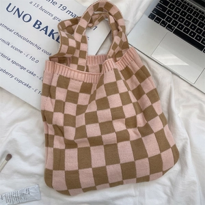 Detail of pink and brown checkered knit tote bag with thick texture on white fabric