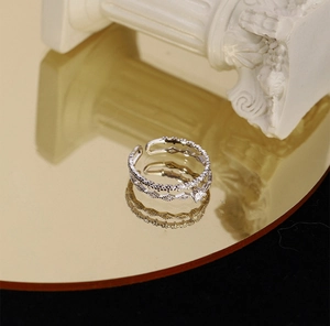 Detailed close-up of a silver double-layer adjustable ring with cubic zirconia stones
