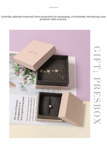 Pink jewelry gift box detail with star pendant gold necklace and solitaire diamond ring
