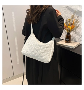 Detail of white star-quilted tote bag showing soft texture on a model side view