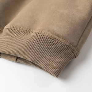 Vue détaillée des poignets en maille côtelée sur la manche d'une veste en daim marron