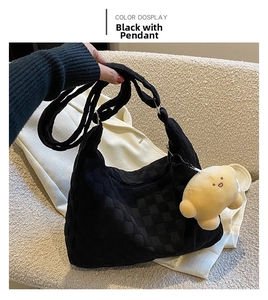 Detail of black checkerboard woven handbag with cute brown plush star pendant