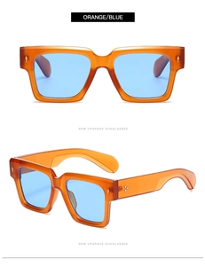 Detail view of square orange frames with blue lenses and golden decorative metal rivets