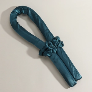 Detail showing the smooth dark cyan satin heatless hair curler and matching scrunchie