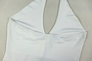 Detail of white halter neck top in glossy stretchy fabric with a slim fit silhouette