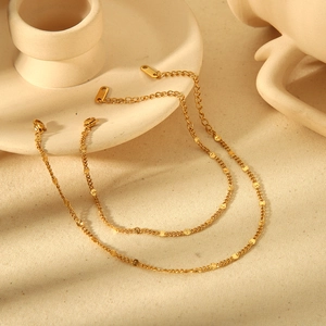 18K gold plated stainless steel circle bead chain necklace displayed on cream fabric