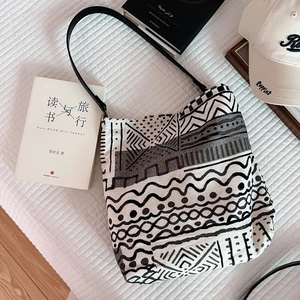 Detail of bohemian linen tote bag with geometric tribal prints and slim leather straps