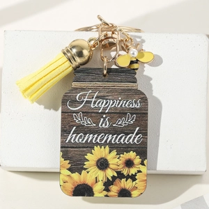 Detail of wooden sunflower keychain with Happiness is homemade text and yellow tassel
