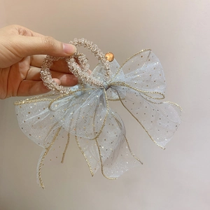 Close-up of light blue mesh bow hair tie with crystal beads and gold polka dots