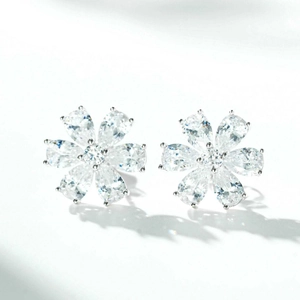 Macro detail of S925 sterling silver flower stud earrings with pear-cut clear gemstones