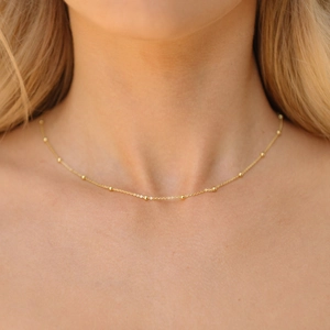 Close-up of minimalist gold plated stainless steel satellite chain with tiny beads