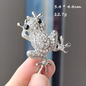 Macro shot of a crystal-encrusted frog brooch with size 3.4x4.4cm and weight 12.7g details