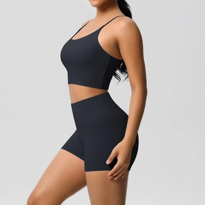Side view of black yoga set featuring slim strap sports bra and high-waisted fitness shorts