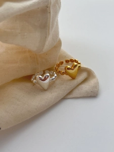 Close-up of 925 sterling silver 3D heart rings with beaded bands in gold and silver