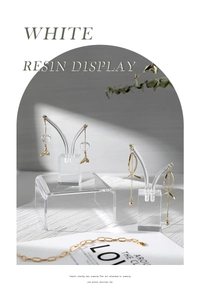 Detail showing acrylic display stands with gold fish-tail earrings and tassel chain jewelry