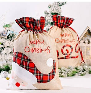 Detail of Christmas burlap gift bags with Santa applique and festive embroidery decor