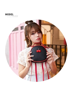 Litchi pattern PU leather crossbody bag with 3D cherry charm held by model