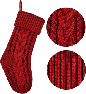 Dettaglio calza di Natale rossa in maglia con trama a trecce e finitura a costine