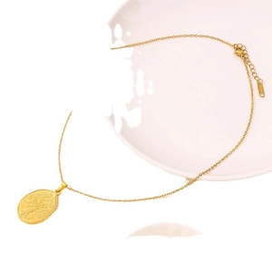 Minimalist gold stainless steel necklace featuring a round tree of life relief pendant