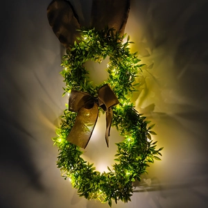 Gros plan de la couronne de Pâques lapin avec lumières LED et oreilles en toile de jute