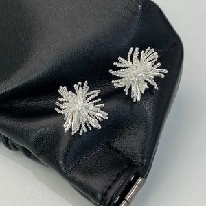 Detailed macro view of silver firework stud earrings with sparkling cubic zirconia crystals