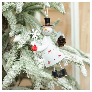 Detailed close-up of a metal snowman angel ornament hanging on a snowy Christmas tree branch