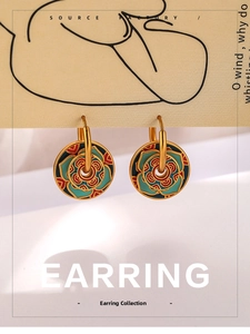 Detailed macro view of gold enamel lotus earrings with red blue and green floral patterns