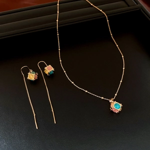 Detailed set of 18K gold plated cat's eye stone necklace and earrings on leather tray