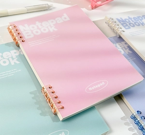 Detail of multi-color frosted plastic notebooks with segmented coil spiral binding
