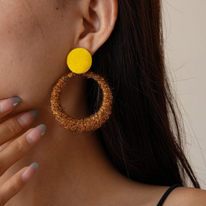 Close-up of vintage hollow round earrings with brown flocking and metallic gold texture