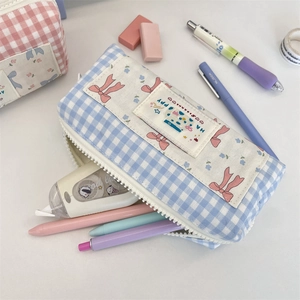 Detail of blue plaid pencil case showing cute bow and large resin zipper closure