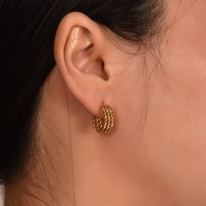 Close-up detail of 18k gold plated 3-line braided hoop earrings, elegant minimalist design.